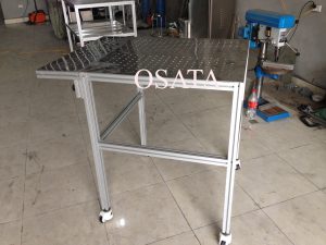 Ảnh chụp thực tế bàn thao tác khung nhôm định hình tại xưởng OSATA. Đặt Alt text: Khung bàn thao tác nhôm định hình gia công tại OSATA